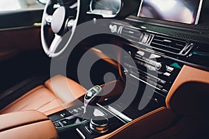 Modern Luxury car inside. Interior of prestige modern car. Comfortable leather brown seats. Orange perforated leather