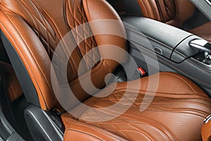 Modern Luxury car inside. Interior of prestige modern car. Comfortable leather red seats. Orange perforated leather cockpit with