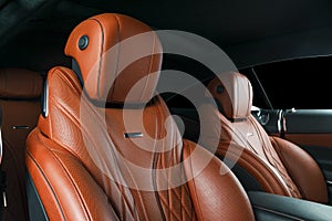 Modern Luxury car inside. Interior of prestige modern car. Comfortable leather red seats. Orange perforated leather cockpit with