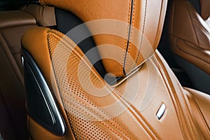 Modern Luxury car inside. Interior of prestige modern car. Comfortable leather red seats. Orange perforated leather. Modern car