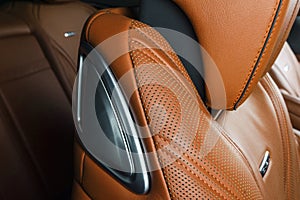 Modern Luxury car inside. Interior of prestige modern car. Comfortable leather red seats. Orange perforated leather. Modern car