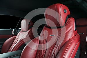 Modern Luxury car inside. Interior of prestige modern car. Comfortable leather red seats. Red perforated leather cockpit