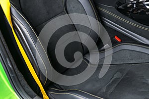 Modern Luxury car inside. Interior of prestige modern car. Comfortable leather seats. Black perforated leather with yellow s