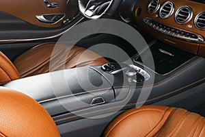 Modern Luxury car inside. Interior of prestige modern car. Comfortable leather seats. Orange perforated leather cockpit. Steering