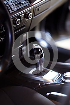 Modern luxury car Interior - steering wheel, shift lever and dashboard.