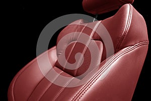 Modern luxury car red leather interior. Part of red perforated leather car seat details with white stitching. Interior of prestige