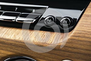 Modern luxury car white interior with natural wood panel. Part of car dashboard. Interior of prestige modern car. Media control bu