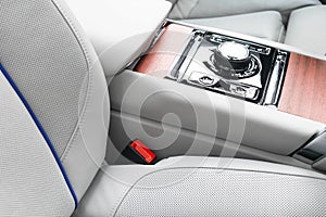 Modern luxury car white leather interior with natural wood panel. Part of leather car seat details with stitching. Interior of pre