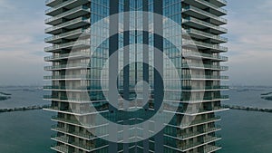 Modern luxury high rise apartment building with balconies and glass facade. Living on sea coast. Abstract computer