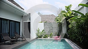 Modern Luxury House With Swimming Pool .Wide shot of empty sunbed at the swimming pool area