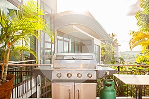 Modern luxury patio with a large grill for summer barbecues in a backyard deck