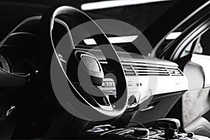Modern luxury prestige car interior, dashboard, steering wheel. Black leather interior
