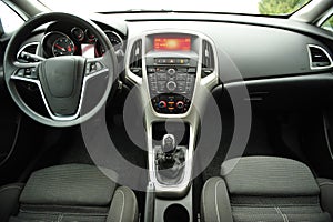 Modern luxury prestige car interior, dashboard, steering wheel. Black perforated leather interior.