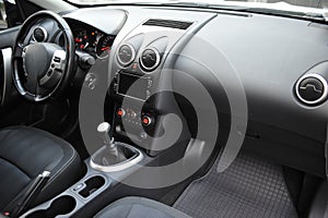 Modern luxury prestige car interior, dashboard, steering wheel. Black perforated leather interior.