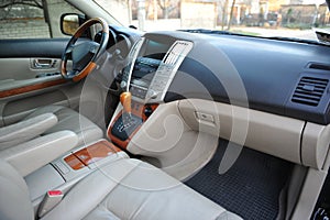 Modern luxury prestige car interior, dashboard, steering wheel. Perforated leather, wooden interior.