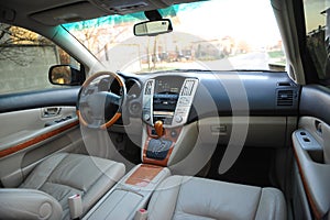 Modern luxury prestige car interior, dashboard, steering wheel. Perforated leather, wooden interior.