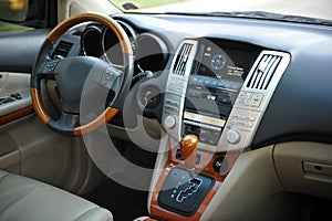 Modern luxury prestige car interior, dashboard, steering wheel. Perforated leather, wooden interior.