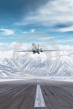 Modern luxury private jet take off airport runway at winter on the background of high scenic snow capped mountains