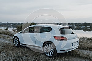 Modern luxury white sedan 2-doors  sport car at the sunset outdoors.