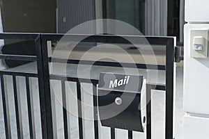 Modern mail box on house fence