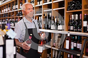 Modern male vintner working in modern wine shop