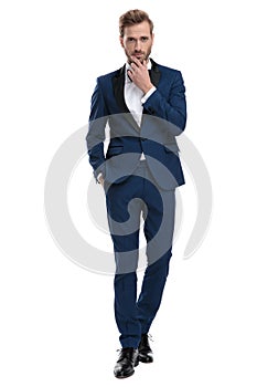 Modern man thinking while standing with hand in pocket