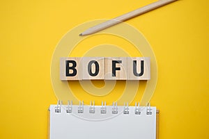 Modern marketing buzzword - BOFU Bottom of funnel. Top view on wooden table with blocks. Top view