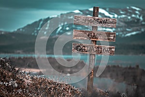 modern mass extinction text quote engraved on wooden signpost outdoors in landscape looking polluted photo