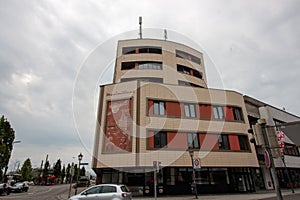 The modern 'Maximilians' building is visible in an urban setting in Memmingen, Germany