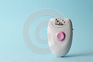 Modern mechanical epilator on a colored background close-up.