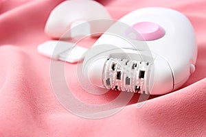 Modern mechanical epilator on a colored background close-up.