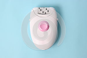 Modern mechanical epilator on a colored background close-up.