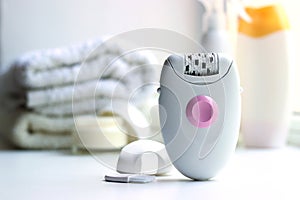 Modern mechanical epilator on a colored background close-up.