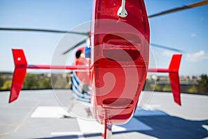 Modern medical helicopter on a hospital rooftop helipad from behind