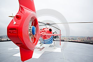 Modern medical helicopter on a hospital rooftop helipad from behind