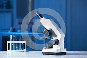 Modern medical microscope on gray table in laboratory, space for text