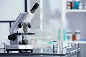 Modern medical microscope on metal table in laboratory, space for text