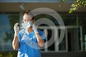 Modern medical practitioner woman outside near hospital