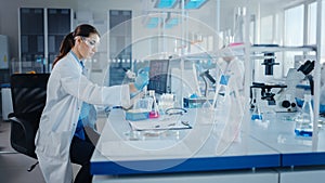 Modern Medical Research Laboratory: Female Scientist Working with Micro Pipette, Using Digital Tab