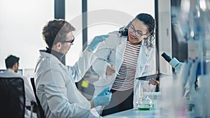 Modern Medical Research Laboratory: Portrait of Two Young Scientists Mixing Liquid Chemicals