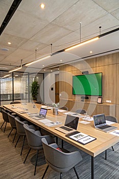 Modern Meeting Room with Conference Table and Green Chroma Key Screen photo