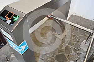 Modern metal automatic turnstile for passing people on plastic cards, passes. Electric checkpoint with a green arrow