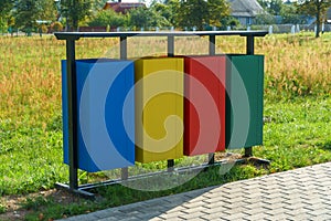 Modern metal containers for separate garbage collection. Garbage cans in the city on the background of a lawn. Environmental