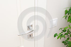 Modern metal door handle and escutcheon for lock with key. Close