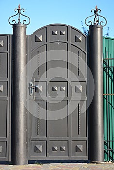 Modern metal fence door on the street side.