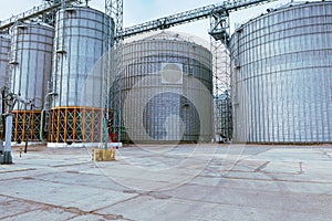 Modern metal grain elevator in agricultural zone. Storage of grain and other different cereals. Sunflower oil factory.