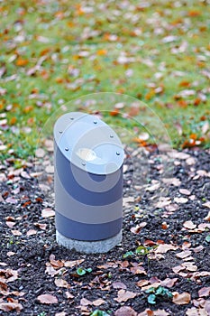 Modern metal spotlight led lamp for outdoor use of circular shape recessed in a grass area