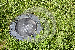 Modern metal spotlight led lamp for outdoor use of circular shape recessed in a grass area