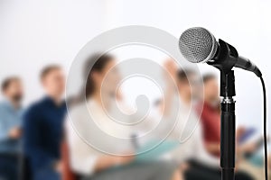 Modern microphone and people at business training, closeup