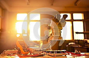 Modern microscope, connectors component and large green microcircuit in workshop laboratory